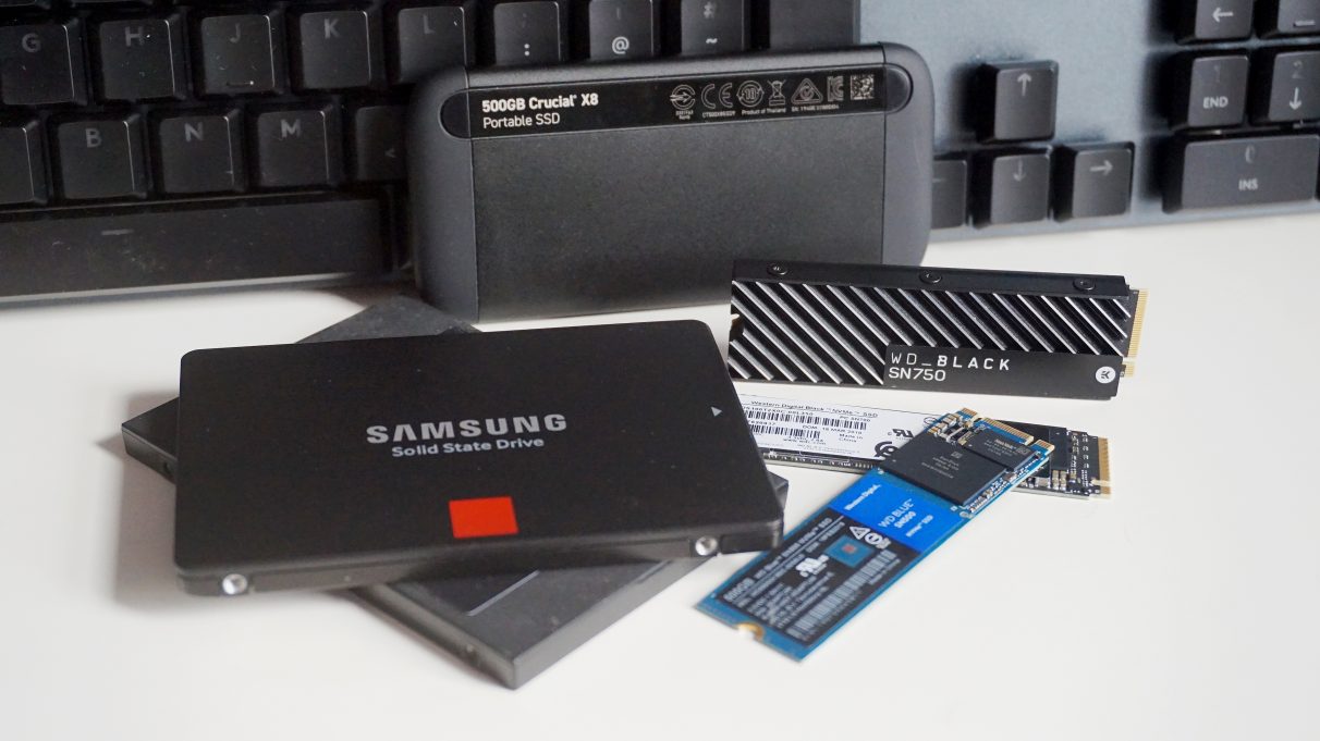 A collection of SATA, NVMe and portable external SSDs on a table.