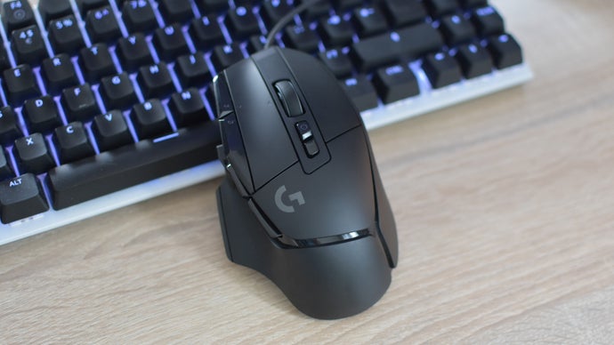 The Logitech G502 X gaming mouse resting against a keyboard.